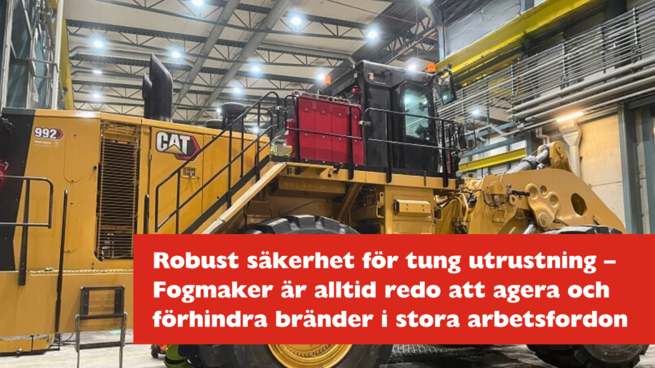 Stor CAT-maskin inomhus med Fogmaker-systemet monterat på maskinens sida.