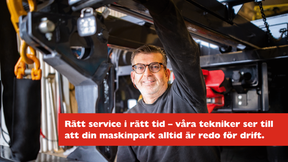 STS-tekniker i verkstadskläder utför service på entreprenadmaskin, fokus på noggrant arbete och säker drift.